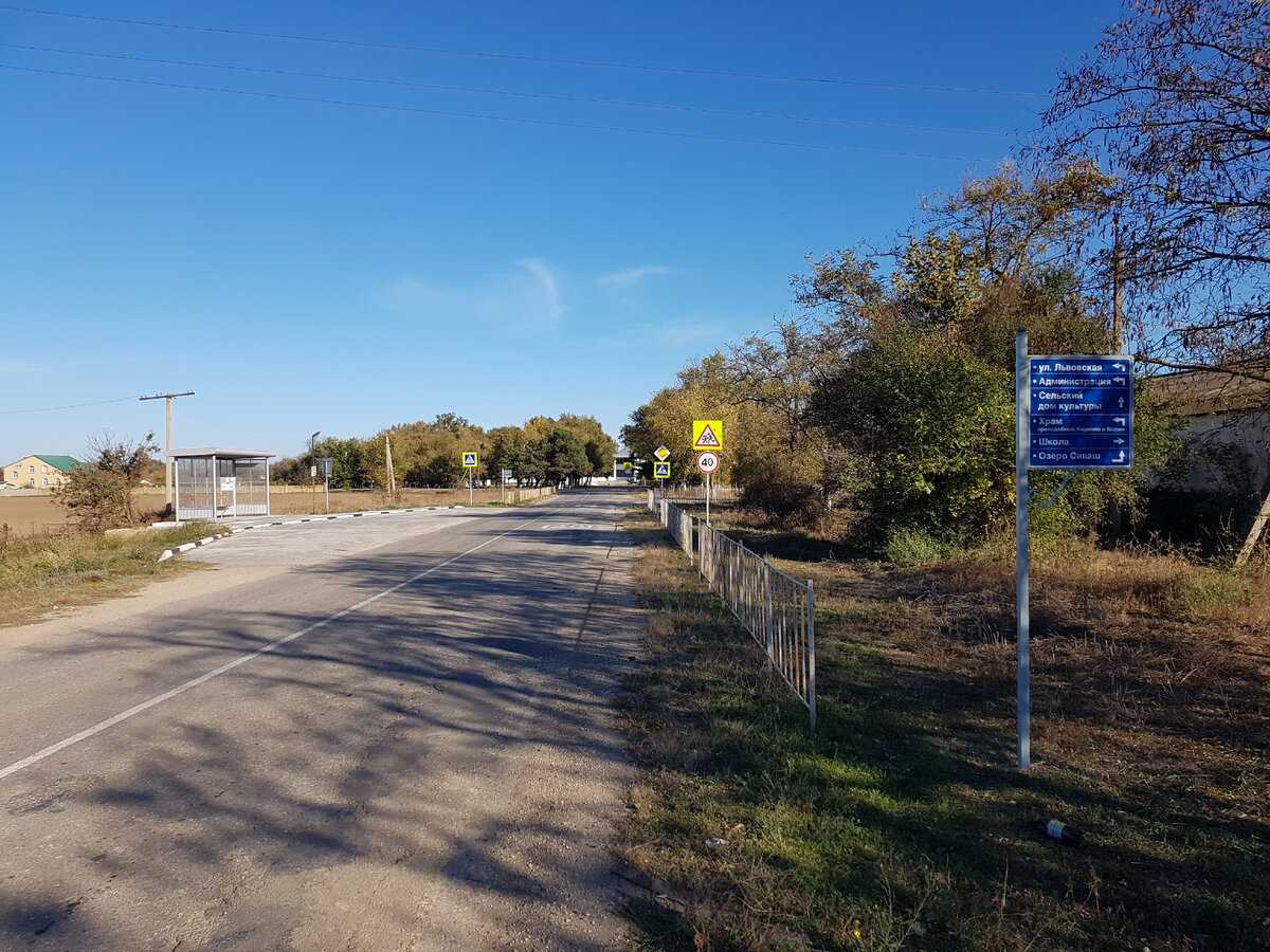 Въехали в Дмитровку. Справа - указатель, слева - остановка. Впереди пешеходный переход и дорожные знаки, всё по уму - всё как положено.